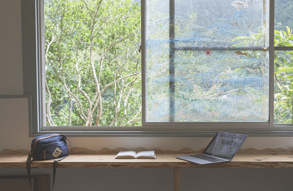 写真：窓際のカウンター席に置かれた手帳とノートPC